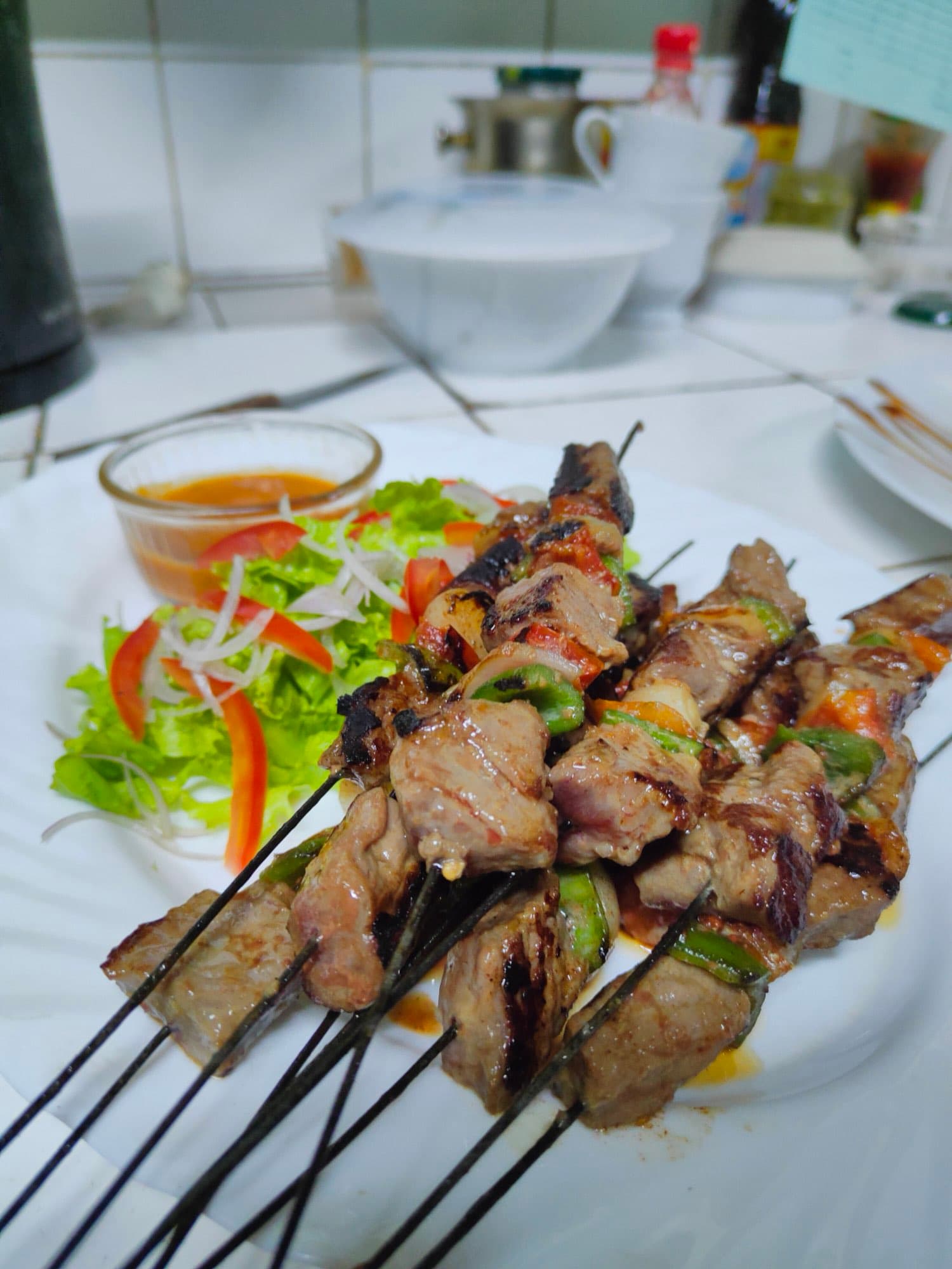 Grilled meat skewers served with fresh salad