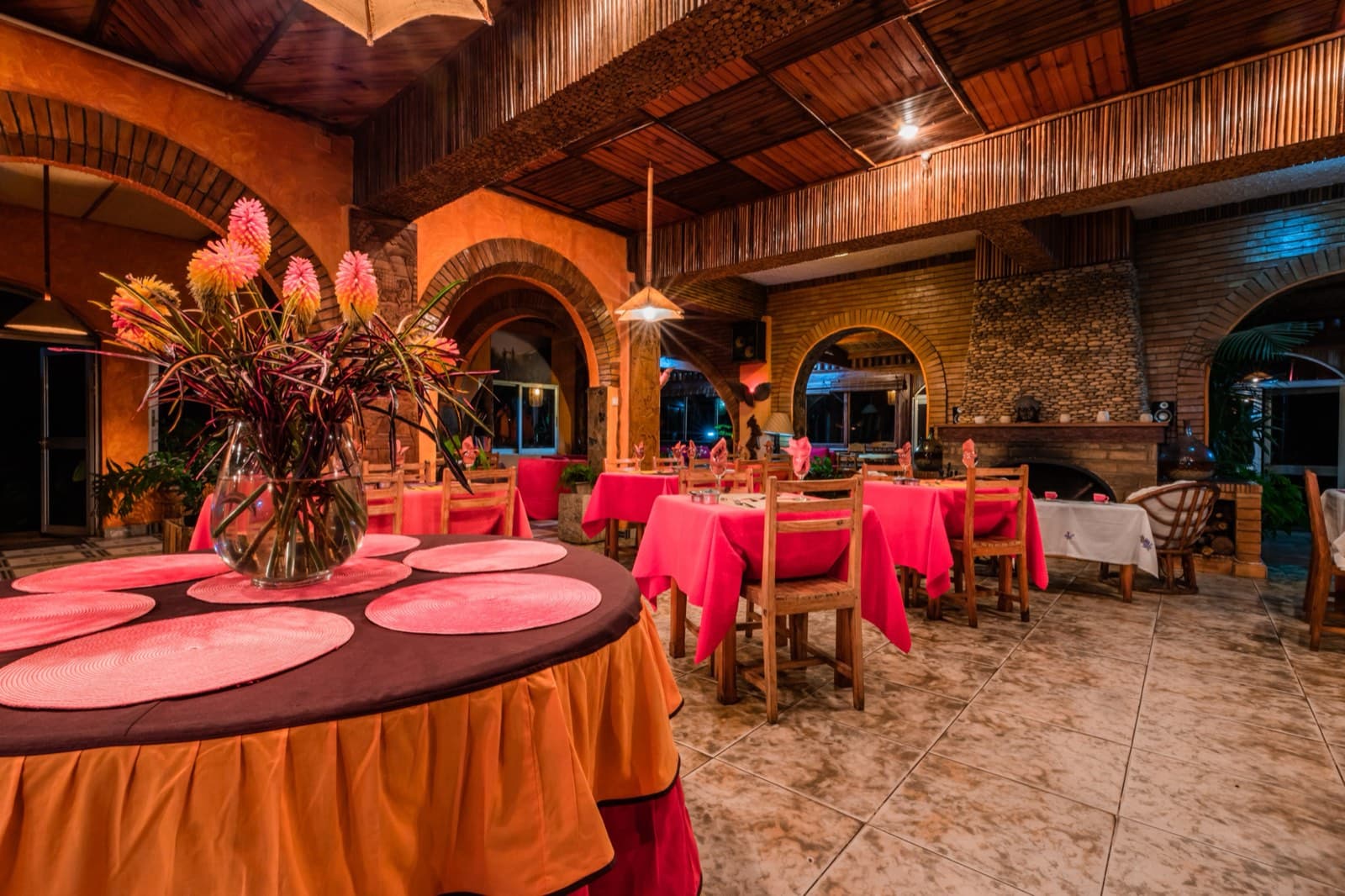 The panoramic restaurant dining room, round tables set beneath the timber roof